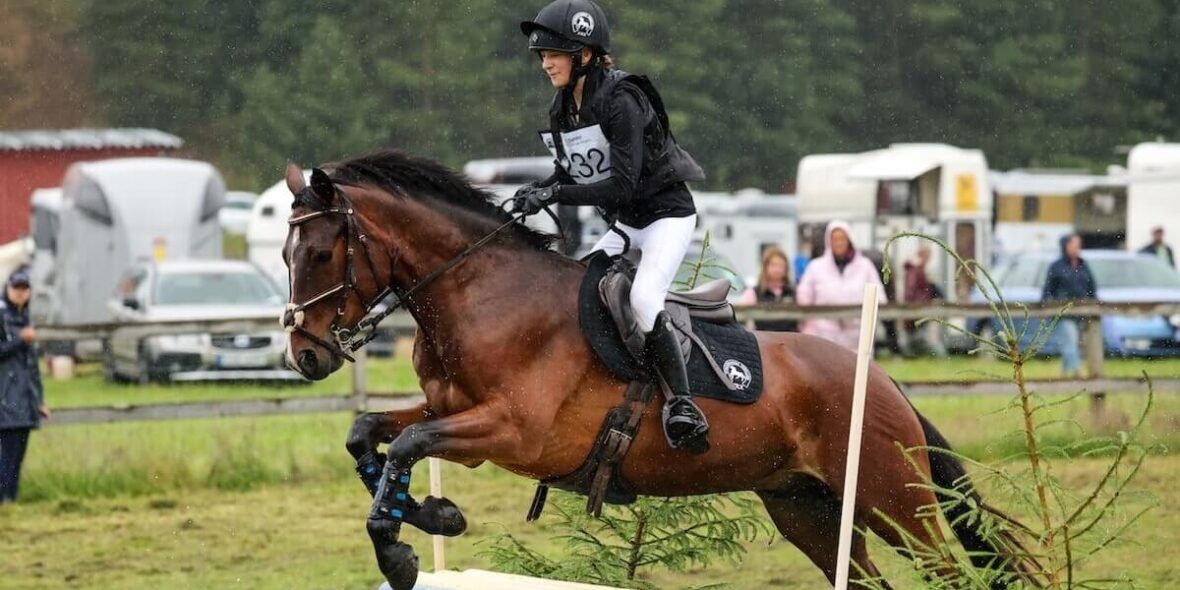 Eventing horse and rider approaching a cross-country fence with calm forward rhythm